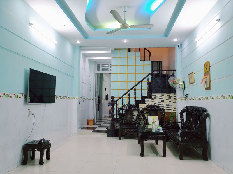 Phòng khách tầng trệt thông suốt, cầu thang gỗ, trần thạch cao